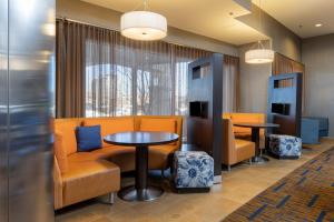 a waiting room with orange chairs and tables at Courtyard by Marriott Asheville Airport in Arden