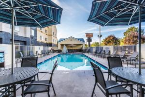 a pool with tables and chairs and umbrellas at Fairfield Inn St. George in St. George