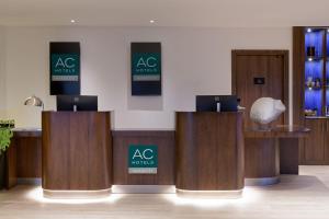 a lobby with wooden booths with aac products signs at AC Hotel by Marriott Saint-Julien-en-Genevois in Saint-Julien-en-Genevois