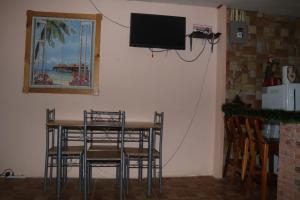 mesa de comedor con sillas y TV en la pared en Casa Hidalgo cerca de playa Carrillo en Carrillo