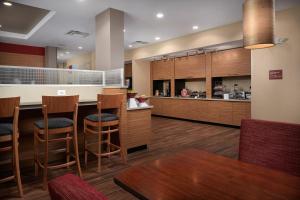 uma cozinha com armários de madeira e um bar com bancos em TownePlace Suites Fort Worth Northwest Lake Worth em Fort Worth
