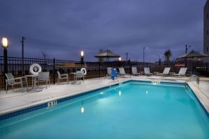 uma piscina num hotel com cadeiras e mesas em TownePlace Suites Fort Worth Northwest Lake Worth em Fort Worth