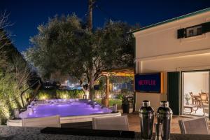 a large purple pool in front of a building at Myronis Villa Corfu Town in Corfu