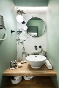 ein Bad mit einem Waschbecken und einem Spiegel in der Unterkunft Athens Luxury Rooms II in Athen