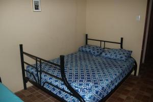 a bed with a blue comforter and pillows in a bedroom at Casa Hidalgo cerca de playa Carrillo in Carrillo