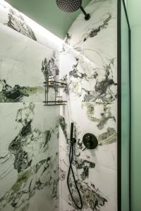 a shower with a black and white marble wall at Athens Luxury Rooms II in Athens