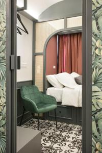a bedroom with a bed and a green chair at Athens Luxury Rooms II in Athens