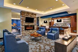 a lobby with blue chairs and a fireplace at TownePlace Suites by Marriott Kincardine in Kincardine