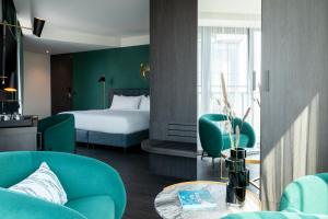 een hotelkamer met een bed en stoelen en een tafel bij The Den, 's-Hertogenbosch, a Tribute Portfolio Hotel in Den Bosch