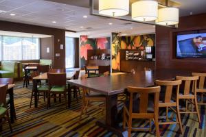 Fairfield Inn & Suites by Marriott Richmond Ashland في آشلاند: غرفة طعام مع طاولات وكراسي وتلفزيون