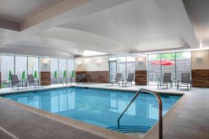 a pool in a hotel with chairs and tables at Fairfield by Marriott Inn & Suites Lewisburg in Lewisburg