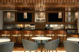 un restaurante con un bar con mesas y sillas en Fairfield by Marriott Inn & Suites Lewisburg, en Lewisburg