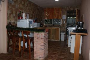 een keuken met een bar met stoelen en een aanrecht bij Casa Hidalgo cerca de playa Carrillo in Carrillo