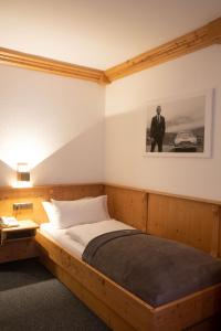 Hotel Stadtkrug في فايدن: غرفة نوم بسرير خشبي مع صورة على الحائط