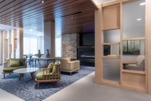 vestíbulo con sillas, mesa y chimenea en Fairfield by Marriott Inn & Suites Revelstoke en Revelstoke