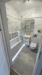 a bathroom with a tub and a toilet and a sink at Apartament z ogrodem in Lublin +4 photos