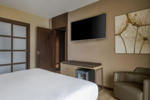 a bedroom with a bed and a tv and a couch at AC Hotel Ciutat de Palma by Marriott in Palma de Mallorca +43 photos