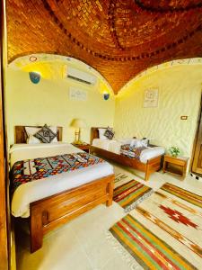 sypialnia z 2 łóżkami i sufitem w obiekcie Kendaka Nubian House w mieście Aswan