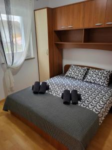 - une chambre avec un lit doté d'oreillers noirs et une fenêtre dans l'établissement Apartma DOLORES, à Vodnjan