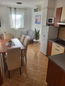 Il comprend une cuisine et un salon avec une table et des chaises. dans l'établissement Apartma DOLORES, à Vodnjan