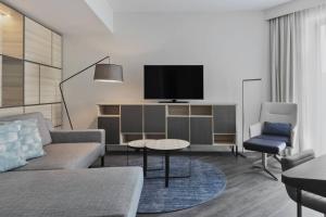 a living room with a couch and a tv at Courtyard by Marriott Hamburg City in Hamburg