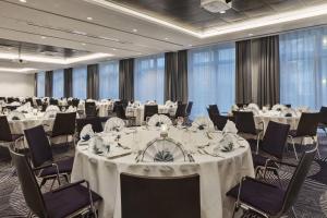 a conference room with tables and chairs with white tablecloths at Courtyard by Marriott Hamburg City in Hamburg