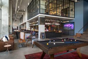a pool table in a room with a bar at Moxy Nashville Vanderbilt Area in Nashville