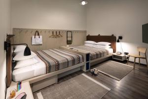 a bedroom with two beds and a table and chair at Moxy Nashville Vanderbilt Area in Nashville