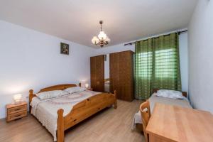 a bedroom with two beds and a table at Apartments Delfin with seaview 100 meters from the sea - by TA Leut Agency in Privlaka