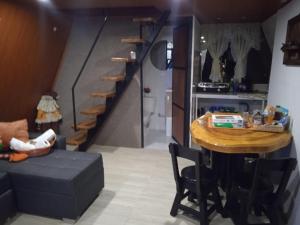 a living room with a table and a stairway at Glamping y Cabañas el Encanto-Girasoles in Tota