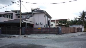 une maison avec une clôture en bois en face d'une rue dans l'établissement Bercham Vacation House, à Ipoh