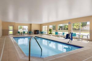 duży basen w hotelu z krzesłami i stołami w obiekcie TownePlace Suites Cedar Rapids Marion w mieście Marion