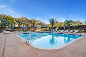 a swimming pool at a resort with chairs and umbrellas at Houston Marriott North in Houston