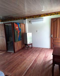 a room with a painting on the wall and a wooden floor at Wikungo Hotel in Puerto Nariño