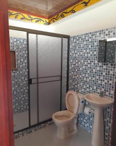 een badkamer met een toilet en een wastafel bij Wikungo Hotel in Puerto Nariño