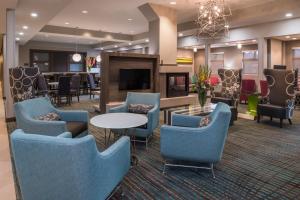 - un hall avec des tables et des chaises bleues et une télévision dans l'établissement Residence Inn by Marriott Decatur, à Decatur