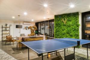 a living room with a ping pong table and a green wall at ULIV Life Tijuana in Tijuana