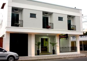 a white building with black doors and windows at Hotel Portobello in Aparecida