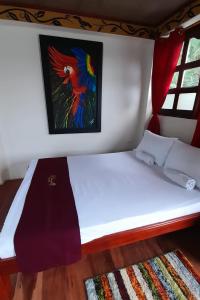 Ce lit se trouve dans un dortoir orné d'une peinture murale. dans l'établissement Wikungo Hotel, à Puerto Nariño
