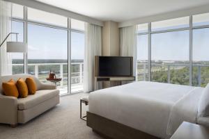 a hotel room with a bed and a tv and windows at JW Marriott Orlando Bonnet Creek Resort & Spa in Orlando