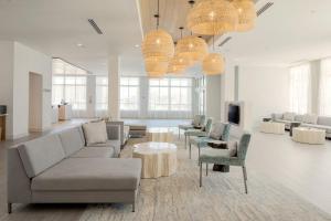 a living room with couches and chairs and a tv at Courtyard Amelia Island in Amelia Island