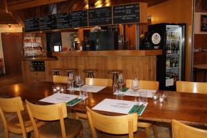 een eetkamer met een houten tafel en stoelen bij Bonne Auberge Les Bugnenets in Le Paquier