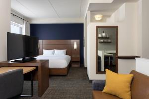 ein Hotelzimmer mit einem Bett und einem Schreibtisch mit einem TV in der Unterkunft Residence Inn By Marriott Philadelphia Bala Cynwyd in Bala-Cynwyd