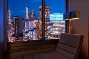 a window with a view of a city skyline at night at W New York - Times Square in New York