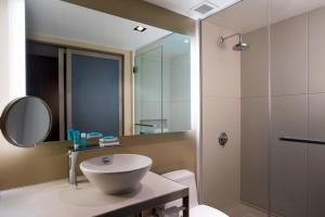 a bathroom with a white sink and a shower at W New York - Times Square in New York