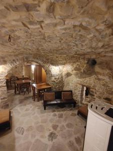 Habitación con pared de piedra, mesa y chimenea. en Borgo Sciugolo, en Baselice