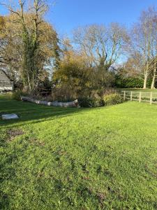 大哈林貝利的住宿－Retreats at Stansted Manor，草场,有栅栏和树木