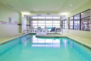a swimming pool with blue water in a building at Courtyard by Marriott Seattle Everett Downtown in Everett
