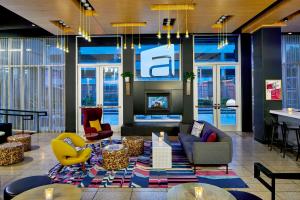 a lobby with couches and chairs and a fireplace at Aloft Austin at The Domain in Austin