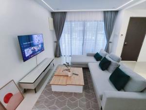 uma sala de estar com um sofá e uma mesa em H+M Residence [5min]to Setia City Convention em Shah Alam